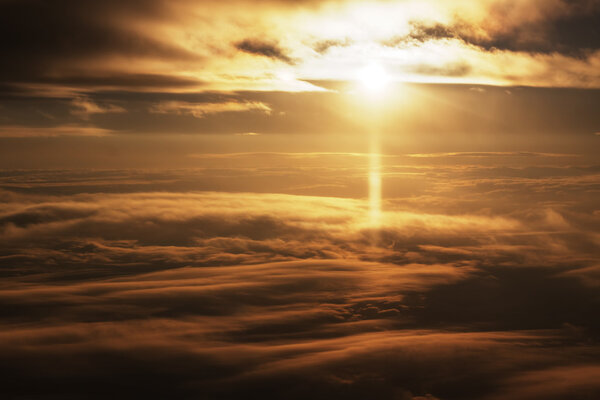 Bright sunlight at sunrise aerial view between two clouds