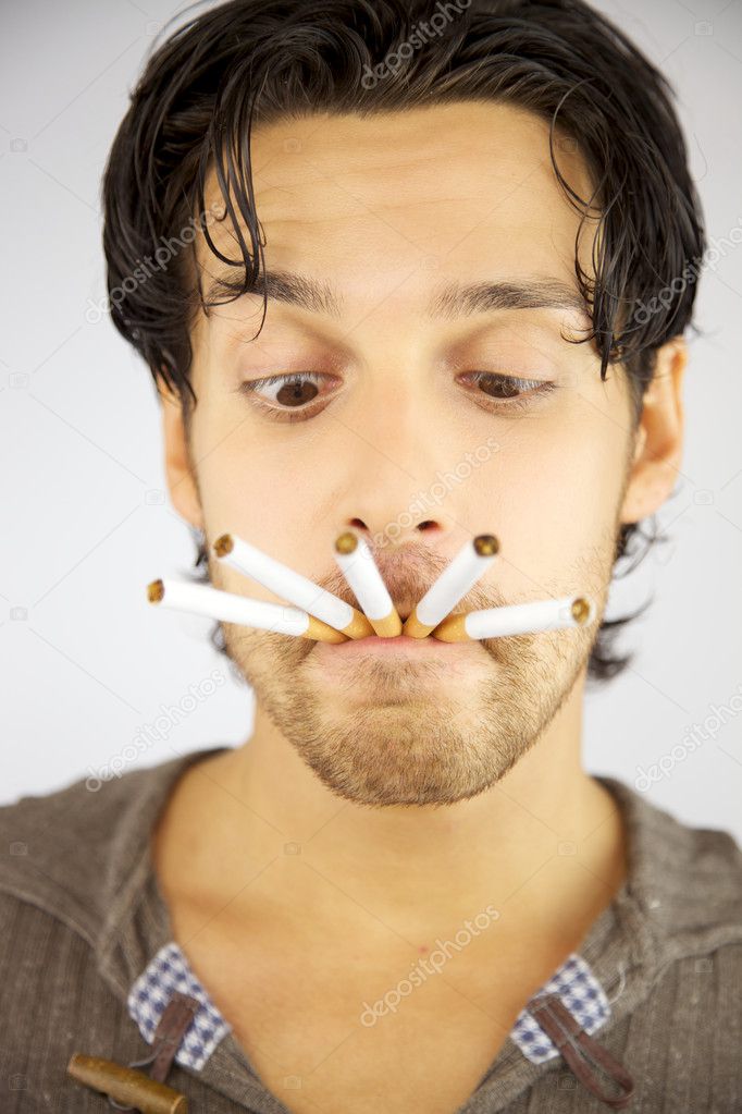 Handsome man with many cigarettes in his mouth ready to smoke addicted