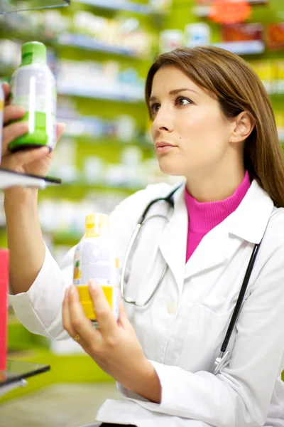Médica feminina em farmácia procurando remédio — Fotografia de Stock