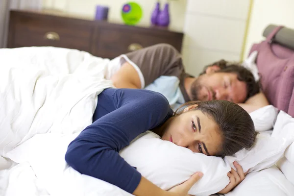 Jovem mulher chorando na cama desesperada sobre o homem dormindo — Fotografia de Stock