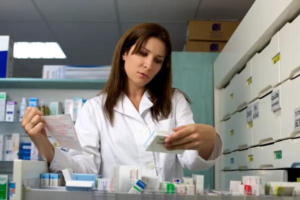 Farmacéutico en farmacia buscando medicina y prescripción — Foto de Stock