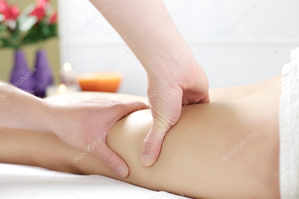 Strong hands working on legs to massage cellulite