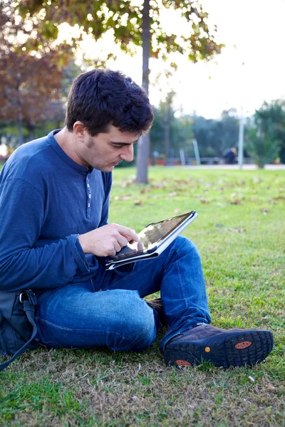 Hombre trabajando con la tableta en el parque — Foto de Stock