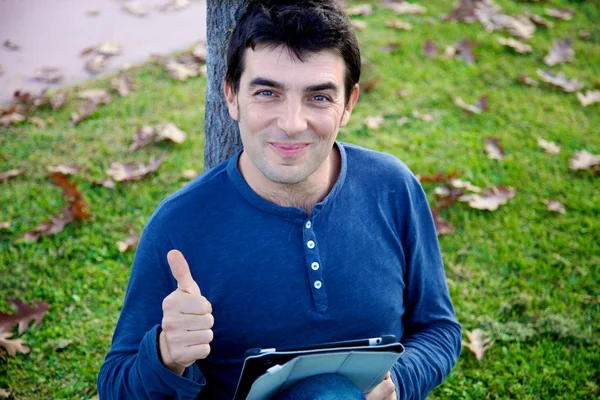 Homem polegar no parque com tablet — Fotografia de Stock