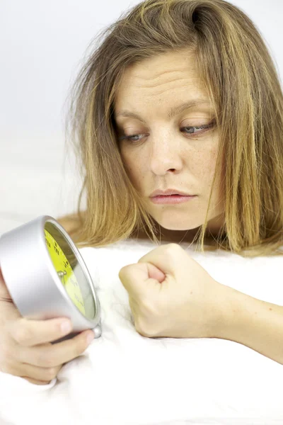 Tired woman angry with alarm clock in the morning — Stock Photo, Image