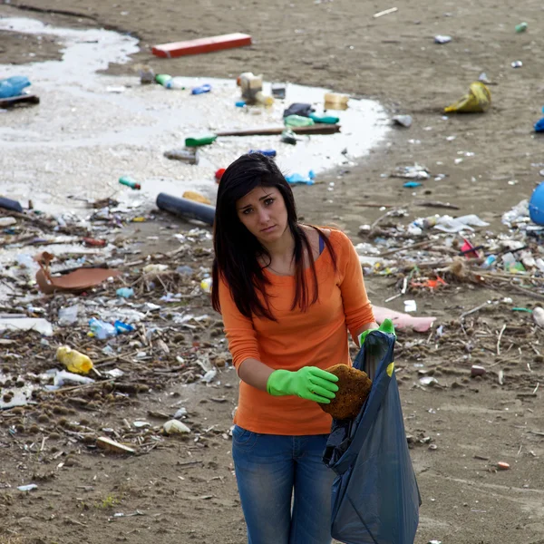 Mulher triste segurando saco de descarga na praia suja — Fotografia de Stock