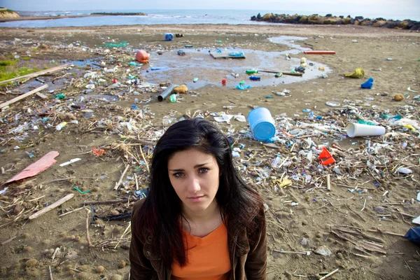 Mujer triste en frente de vertedero y playa sucia — Foto de Stock