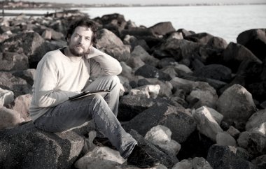 yakışıklı genç tablet çalışırken rahatlatıcı ile sahilde