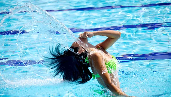 güzel bir kadın yüzme havuzunda su ve saç ile eğleniyor
