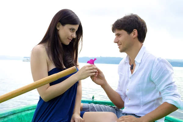 Pojkvän donera rosa blomma till flickvän i kärlek — Stockfoto