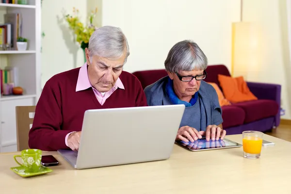 Senior couple in love with technology tablet and computer