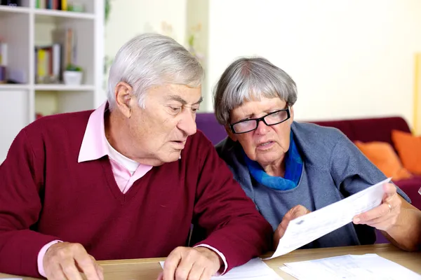 Старша пара читає рахунки вдома Стокове Зображення