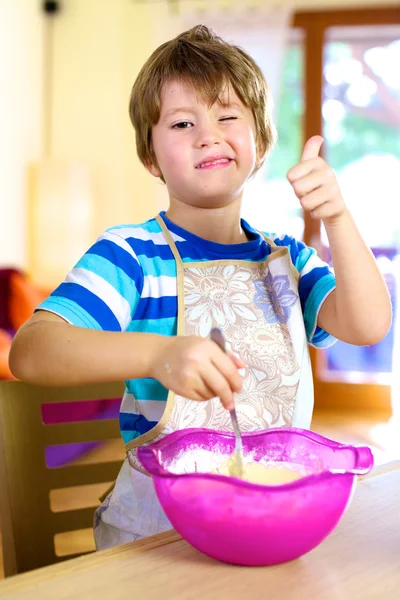 Thumb up for little happy kid cooking at home — Stock Photo, Image