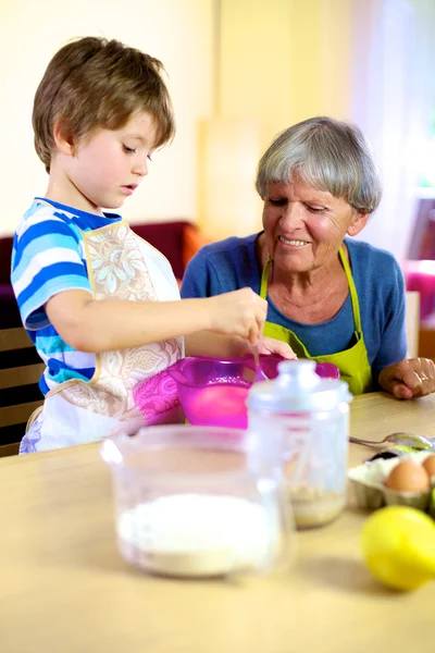 Mutlu büyükanne torunu kek pişirme yardım — Stok fotoğraf