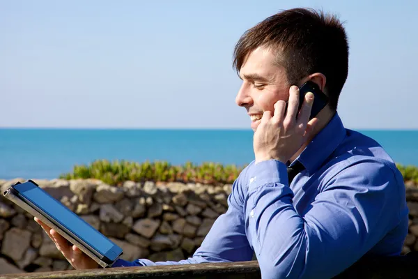 Hombre de negocios guapo trabajando frente al océano — Foto de Stock