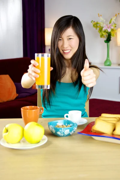 Söt asiatisk kvinna att ha hälsosam frukost med frukt och apelsinjuice — Stockfoto