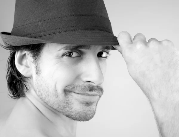 Portrét šťastný usměvavý pohledný muž s kloboukem černá a bílá — Stock fotografie