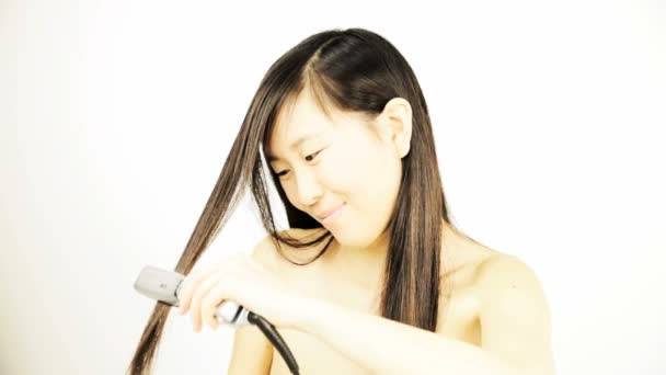 Mujer asiática planchando el pelo largo — Vídeos de Stock