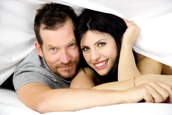 Happy couple in love smiling in bed — Stock Photo, Image