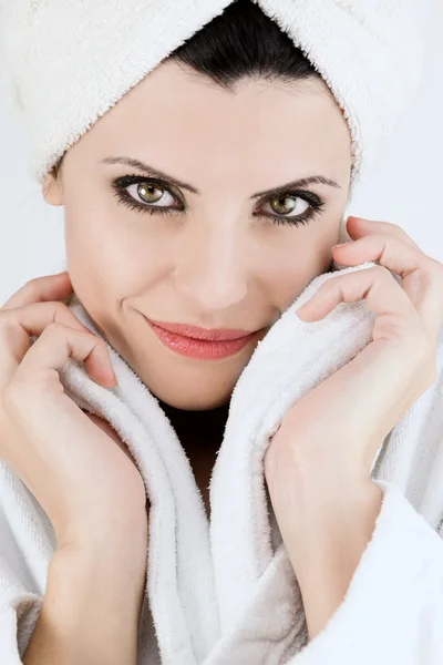 Mujer sonriente con albornoz y toalla en la cabeza sonriendo — Foto de Stock