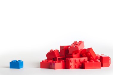 Kırmızı lego blokları ve bir mavi blok büyük bir grup