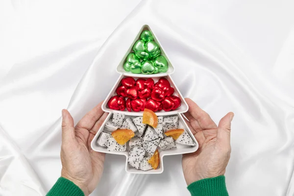 Hands Holding Christmas Tree Shaped Plate Filled Chocolate Candies Sliced — Stock Photo, Image