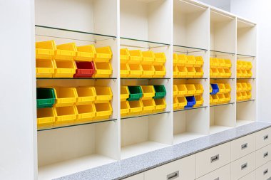 Modern stil depolama raflarında parlak renkli plastik tepsiler.