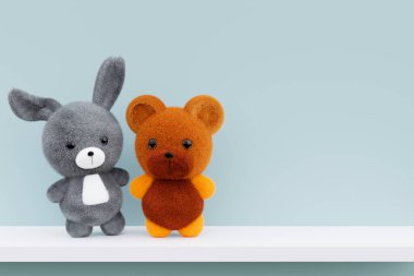 Beyaz bir rafta pofuduk bir bebek tavşan ve oyuncak ayının üç boyutlu çizimi..