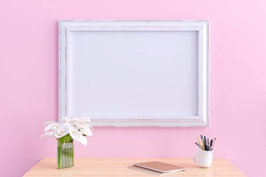 Ahşap bir masanın üzerinde pembe duvar arkaplanı olan bir resim çerçevesinin 3D çizimi.