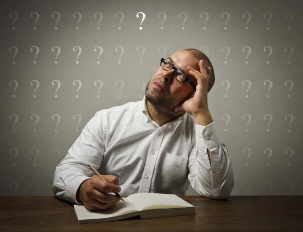 Man in white and question marks. — Stock Photo, Image