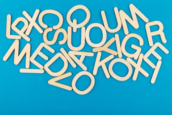 Buchstaben Aus Holz Auf Blauem Papier Viele Hölzerne Buchstaben Mit — Stockfoto