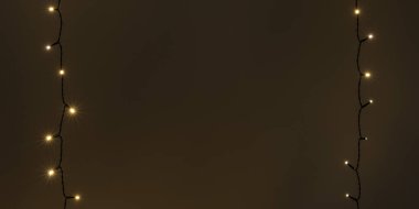 Çelenk. Karanlık duvardaki Noel ağacı ışıkları. Kopya alanı olan kırsal Yeni Yıl siyah arkaplan.