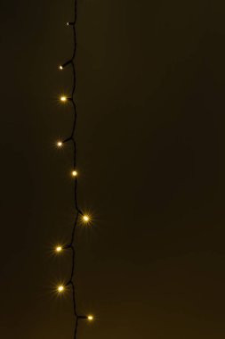 Çelenk. Karanlık duvardaki Noel ağacı ışıkları. Kopya alanı olan kırsal Yeni Yıl siyah arkaplan.