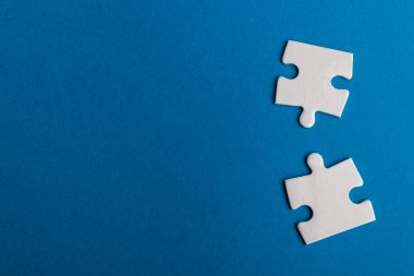 Mavi arka planda beyaz yapboz parçaları. Metin için alanı olan bir desen fotoğrafı. Takım çalışması kavramsal fotoğraf.