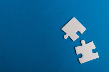 Mavi arka planda beyaz yapboz parçaları. Metin için alanı olan bir desen fotoğrafı. Takım çalışması kavramsal fotoğraf.