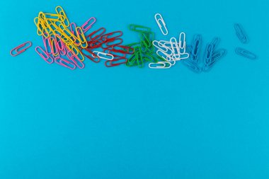 Renkli ataçlar. Renkli ataçlar makro, mavi bir arkaplanda kopyalama alanı ile izole edilmiş olarak kapat.