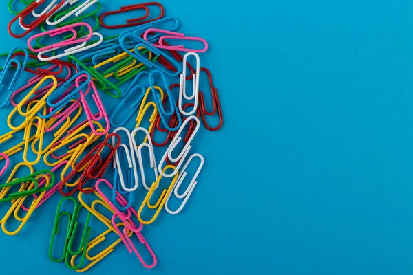 Renkli ataçlar. Renkli ataçlar makro, mavi bir arkaplanda kopyalama alanı ile izole edilmiş olarak kapat.