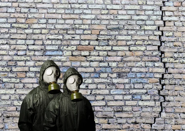 防毒面具两个人带着防毒面具和砖墙 后面有复制空间 化学武器的危险 — 图库照片