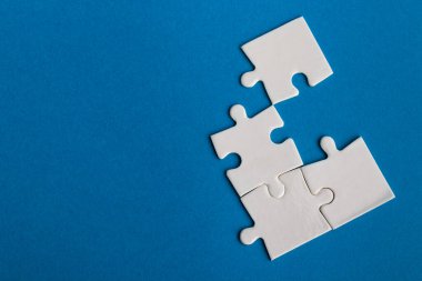 Mavi arka planda beyaz yapboz parçaları. Metin için alanı olan bir desen fotoğrafı. Takım çalışması kavramsal fotoğraf.