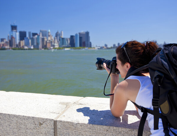 Pretty female photographer taking a picture of New York