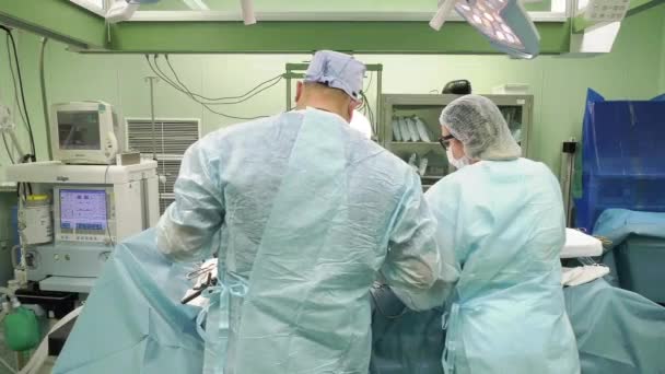 Команда професійних багаторасових лікарів, що проводять операцію в лікарняній кімнаті — стокове відео