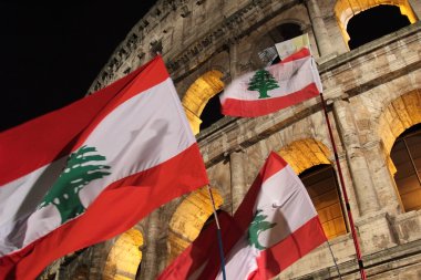 Flags of Lebanon in front of Colosseum during Way of the Cross clipart