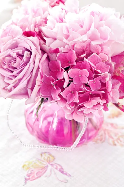 Roze bloemen op een tafel — Stockfoto