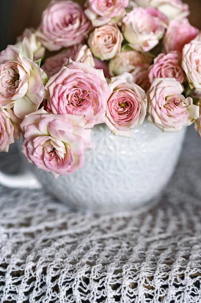 Piękne Róże Filiżance Wiele Pięknych Świeżych Róż Stole Miękkie Skupienie — Zdjęcie stockowe