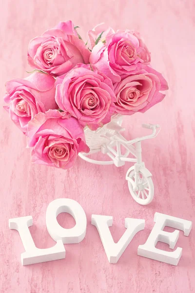 粉红玫瑰花朵装饰的白色木制自行车粉红的底色上 为婚礼或生日鲜花礼品 — 图库照片