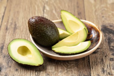 Avokado ahşap bir masada izole edilmiş.