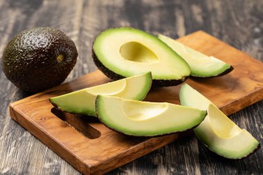 Avokado ahşap bir masada izole edilmiş.