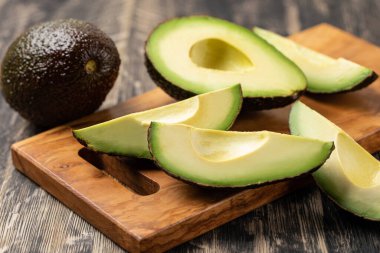 Avokado ahşap bir masada izole edilmiş.