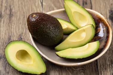 Avokado ahşap bir masada izole edilmiş.