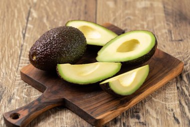 Avokado ahşap bir masada izole edilmiş.